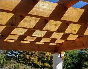 12 x 16 Rustic Solace Pergola shown with Clear Stain/Sealer, Stainless Steel Hardware, 16" Top Runner Spacing, and Customer Supplied Lighting Kit.